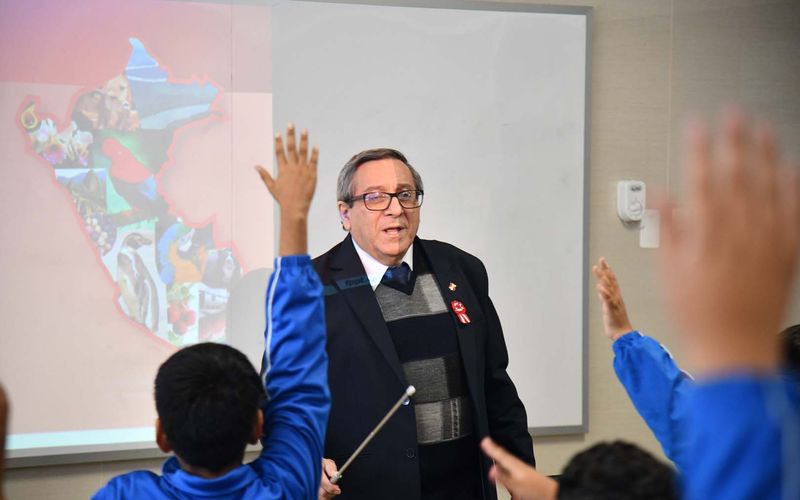 Estudiantes de primaria levantando la mano para participar en clase
