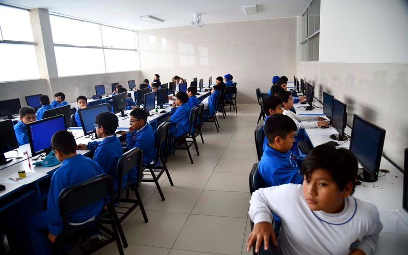 Estudiantes de primaria y secundaria trabajando en el aula de cómputo