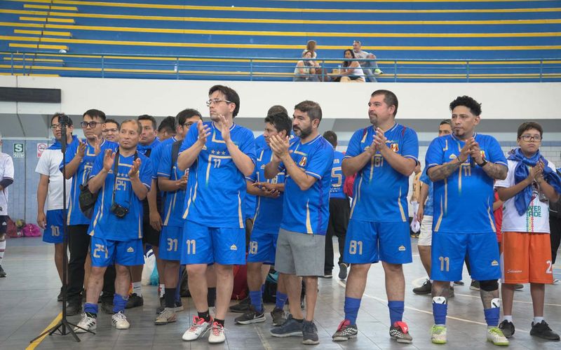 Padres de familia aplaudiendo en el coliseo durante la premiación del campeonato