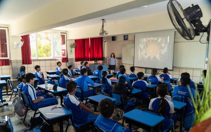 Estudiantes de secundaria atentos a una presentación proyectada en el aula