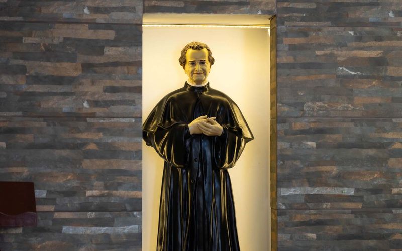 Imagen de Don Bosco en una hornacina iluminada