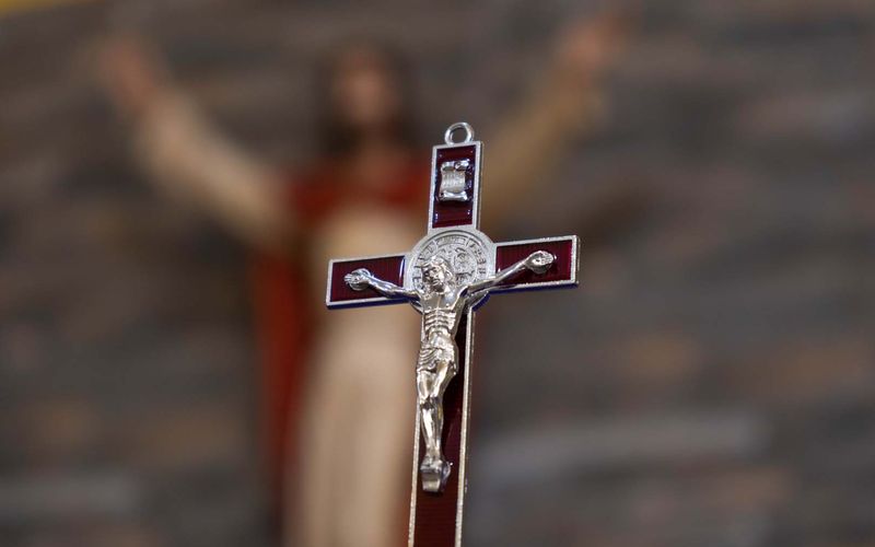 Crucifijo en primer plano con la imagen de Cristo desenfocada
