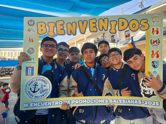 Grupo de jóvenes sonríe tras el marco «Bienvenidos» del III Encuentro de Promociones Salesianas 2025